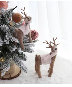 Primo piano dettagliato di simpatiche renne in feltro con sciarpe rosa per Natale.