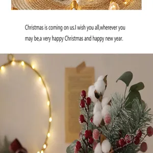 Détail d'arrangement floral de Noël avec du coton, des baies rouges et des branches de pin.