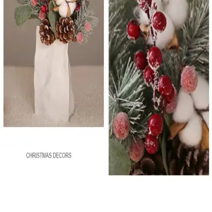 Détail d'arrangement floral de Noël avec baies rouges, pommes de pin, coton et vase décoratif.