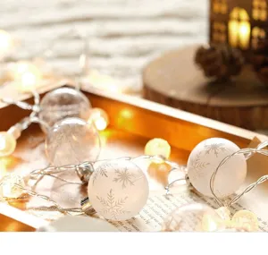 Close-up of Christmas snowflake ball string lights with warm glowing LEDs for cozy decor.