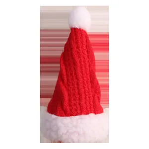 Rote gestrickte Weihnachtsmütze mit weißem Plüschrand und Bommel, dicke Festtags Party Deko Requisite.
