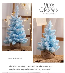 Blauwe geflockte kerstboom tafeldecoratie met jute voet voor gezellige feestelijke sfeer.
