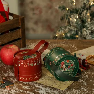 Weihnachtliche runde Geschenkschachtel mit Ledergriff fuer suesse Aepfel und Praesente.