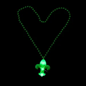 Detailed close-up of the green LED glowing fleur-de-lis pendant necklace for holiday party.