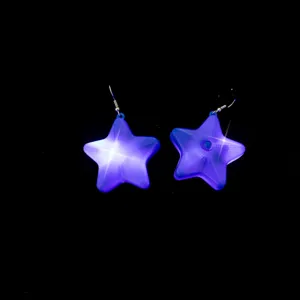Blue purple glowing star earrings, party jewelry detail shot. Glowing pentagram design.