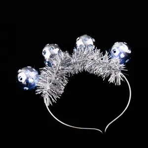 Closeup of silver tinsel headband with reflective disco balls for festival party accessories.
