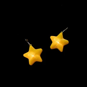Close-up detail view of glowing yellow star earrings, perfect for festive party nights.