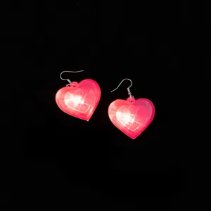 Pink glowing heart earrings with LED lights, romantic style detail shot for party wear.