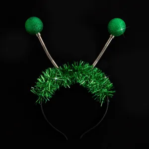 Gros plan sur le serre-tête guirlande vert avec antennes scintillantes et ressorts souples.
