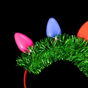 Detail shot of Christmas holiday headband with large colorful bulb decorations and green tinsel.