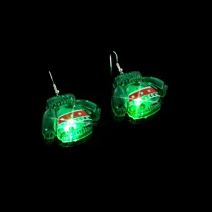 Detail shot of Christmas glowing sweater earrings, transparent green resin luminous holiday ear jewelry.
