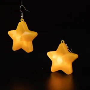 Detail view of glowing yellow star pendant earrings, translucent design, perfect for fashion wear.