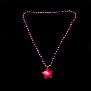 Detailaufnahme der leuchtenden rosa Sternanhänger Halskette mit Perlenkette und Pentagramm.