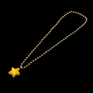 Detaillierte Nahaufnahme der eleganten goldenen Perlenkette mit gelbem Sternanhänger.