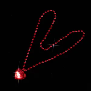 Close-up detail of a glowing red heart pendant necklace with red bead chain, perfect for parties.