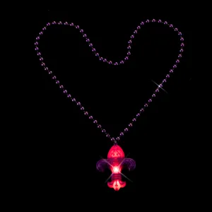 Close-up detail view of the glowing LED fleur-de-lis pendant and purple beaded necklace.