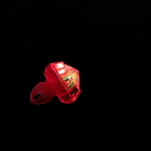 Detailaufnahme eines leuchtenden roten Plastik-Spielzeugrings mit funkelndem Diamantdesign.