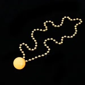 Close-up detail of the glowing yellow pendant and golden bead chain, perfect party accessory.