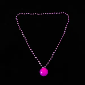 Detailed close-up of a glowing purple bead necklace with a luminous sphere pendant for parties.