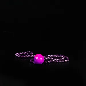 Glow ball bead necklace detail shot, purple disco ball pendant, party night club jewelry accessory.