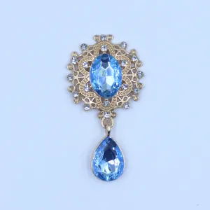 Detail view of vintage alloy rhinestone flower brooch component with blue crystal drops.