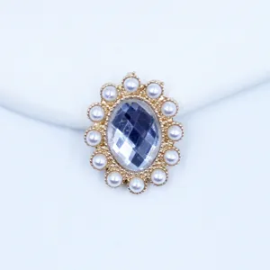 Close-up detail of oval acrylic rhinestone and pearl alloy button for DIY craft accessories.
