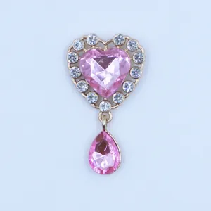 Detailed close-up of a golden alloy heart rhinestone DIY pendant with pink crystal and drop charm.