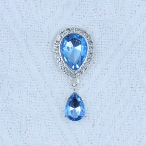 Close-up detail of silver teardrop rhinestone pendant with blue crystal for DIY crafts.