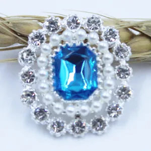 Detailed close-up of alloy rhinestone flower button with blue crystal and pearls for DIY decor.