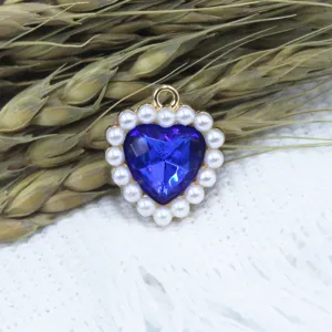 Alloy blue crystal heart pendant with faux pearl border detail shot for DIY jewelry making.