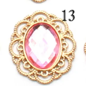 Close-up detail view of the gold filigree metal base with pink faceted acrylic stone.