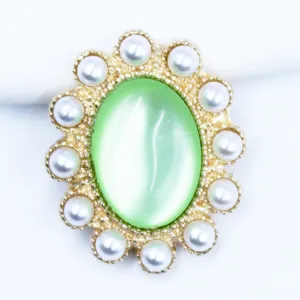 Close-up detail of vintage green cat eye stone with pearl border alloy DIY jewelry accessory.
