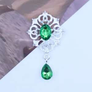 Detailopname van zilveren legering strass hanger met groene druppelvormige kristal.
