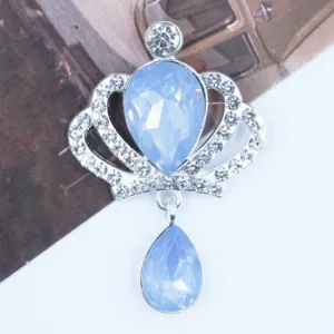 Close-up of silver alloy crown rhinestone pendant with light blue crystal detailing.