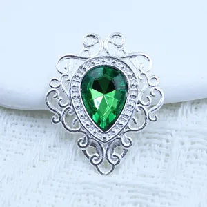 Close-up van vintage zilveren legering hanger met groene druppel kristal diy sieraden.