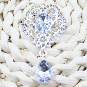 Detailed close-up of a silver alloy rhinestone flower pendant with a clear crystal drop.