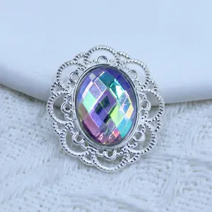 Close-up detail shot of oval iridescent rhinestone alloy filigree DIY jewelry button component.