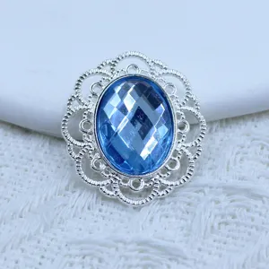 Close-up detail of blue acrylic rhinestone with silver alloy hollow flower base for DIY jewelry.