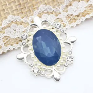 Gros plan sur broche ovale en alliage argenté et strass pierre bleue accessoire DIY.