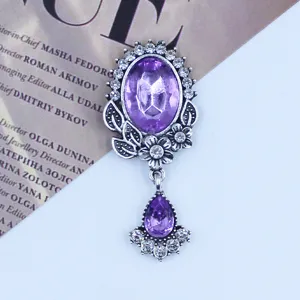 Close-up detail of vintage antique silver alloy rhinestone and acrylic pendant jewelry piece.