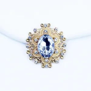 Close up detail of oval golden alloy rhinestone button for DIY hair accessories and crafts.