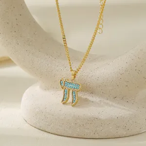 Stunning gold tone Hebrew Chai necklace detail with vibrant turquoise stone pendant close up.