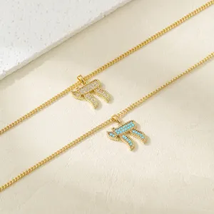 Close-up of Hebrew Chai pendant necklace, gold chain with crystal and turquoise details.