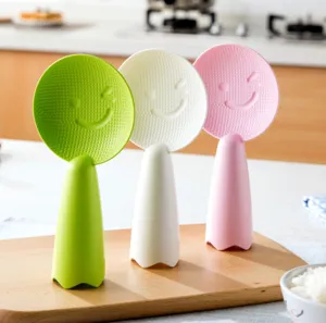 Primer plano detallado de cucharas de arroz de pie creativas en verde, blanco y rosa con sonrisa.