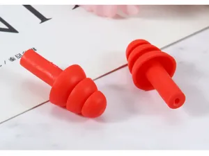 Detailopname van rode siliconen oordopjes met meerdere flenzen voor geluidsreductie.
