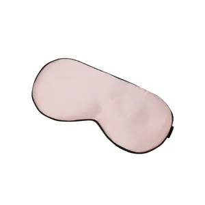 Maschera per dormire in pura seta rosa chiaro con bordo nero per un sonno confortevole.