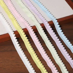 Colorful pom pom fringe trim detail showing pastel yarn ribbons with tiny balls for DIY sewing.