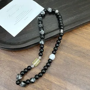 Detailed shot of handmade beaded bracelet with mixed black and multi-colored beads.