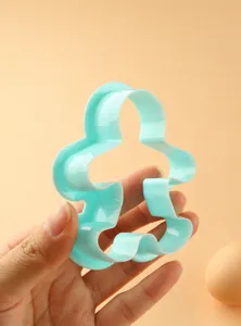 Blue plastic Christmas gingerbread man cookie cutter detail view, hand-pressed baking tool.
