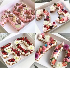 Detail view of number shaped cakes decorated with cream and fruits made using baking molds.